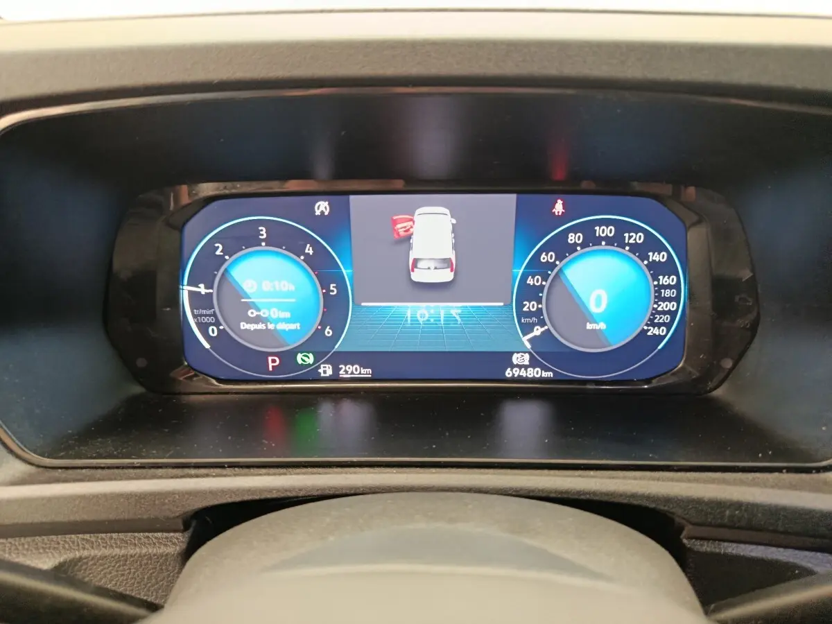 Vue rapprochée du tableau de bord numérique du Volkswagen Caddy 2022 affichant la vitesse et les alertes.
