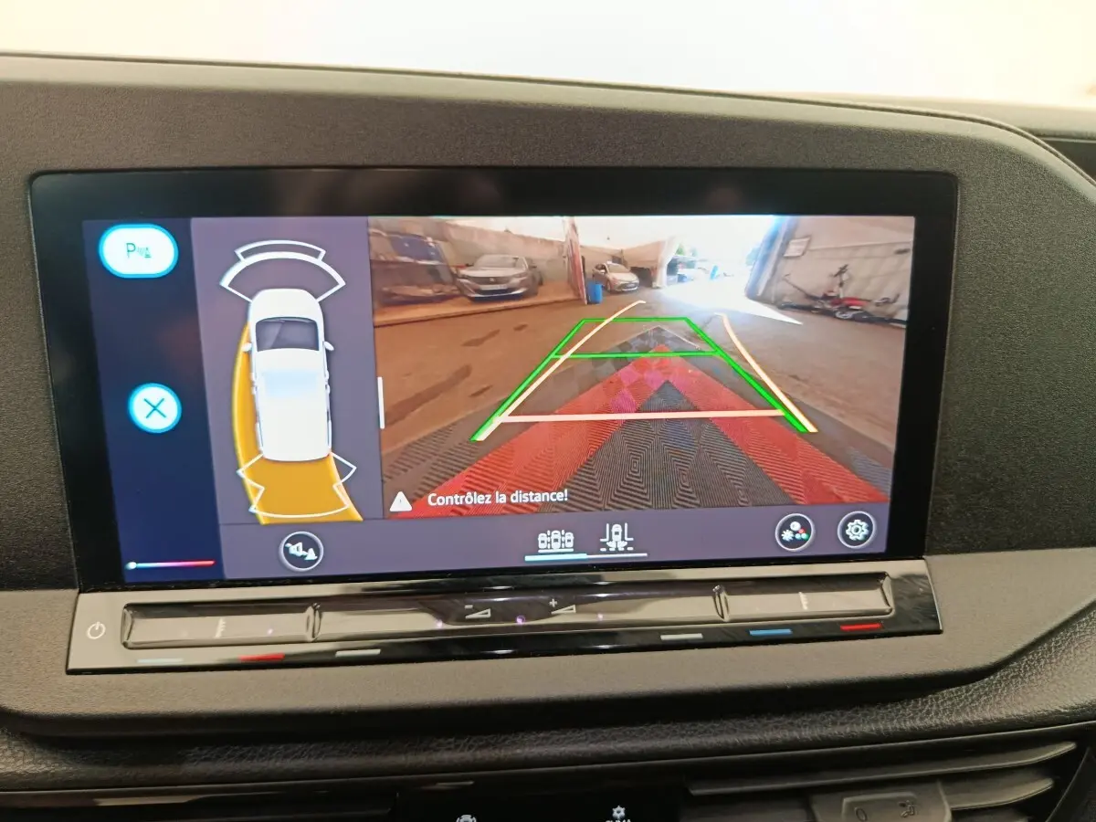 Écran tactile central du Volkswagen Caddy blanc 2022 affichant la caméra de recul avec guidage de trajectoire.