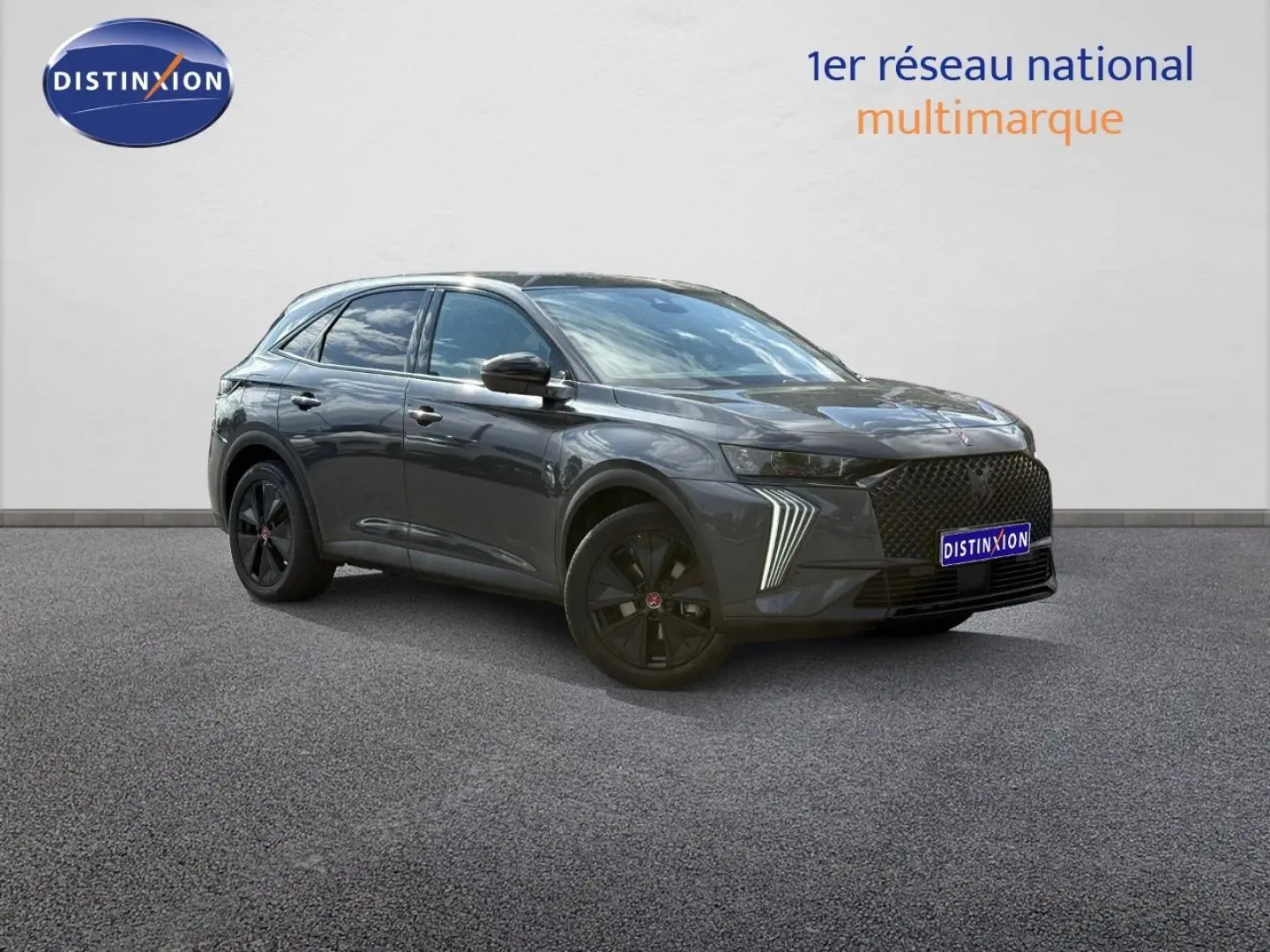 DS7 E-TENSE gris titane en 3/4 avant droit, avec jantes noires et feux LED distinctifs allumés.