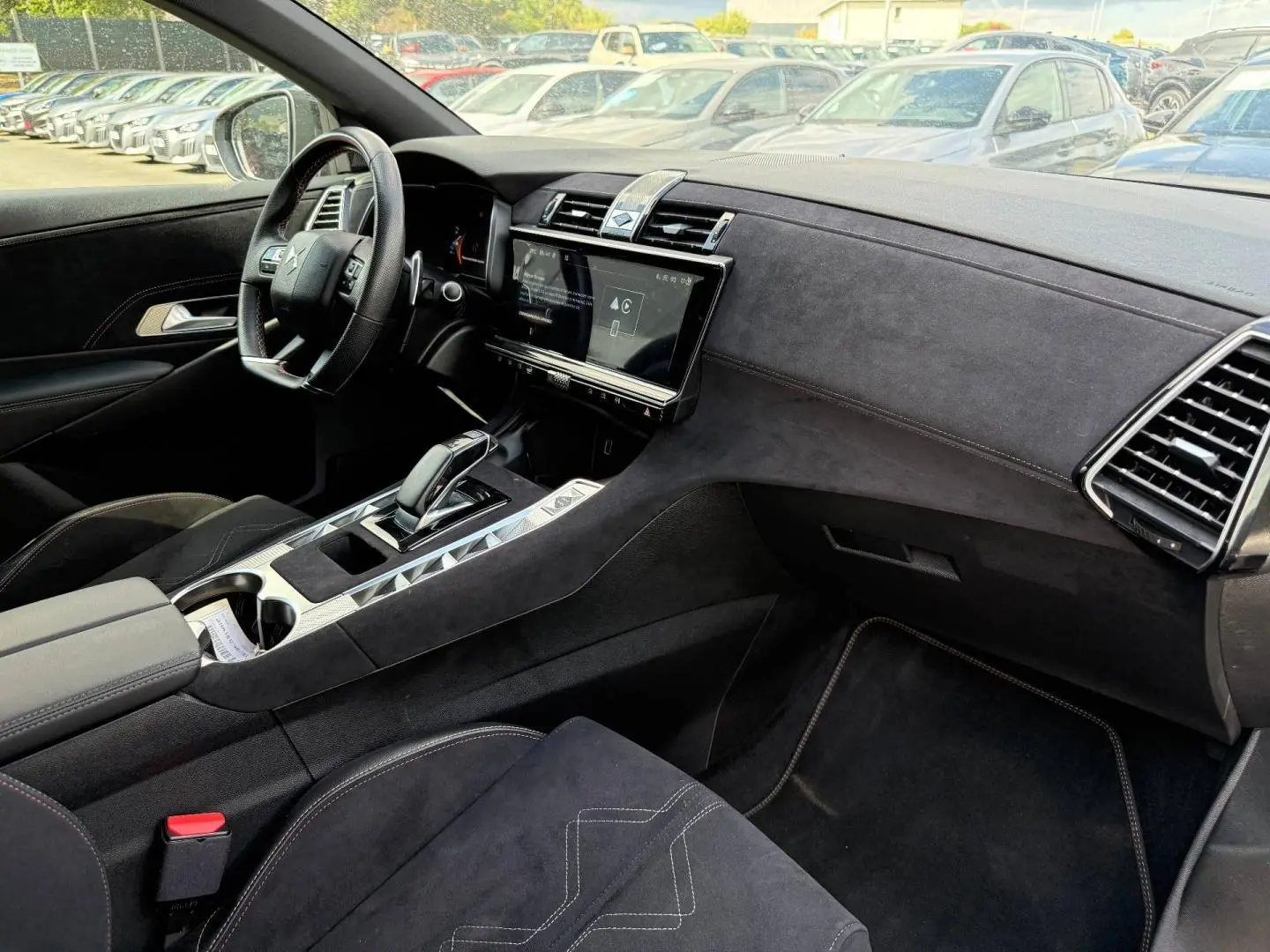 Vue intérieure côté conducteur du DS7 E-TENSE 2024, montrant la planche de bord et la console centrale en Alcantara noir.