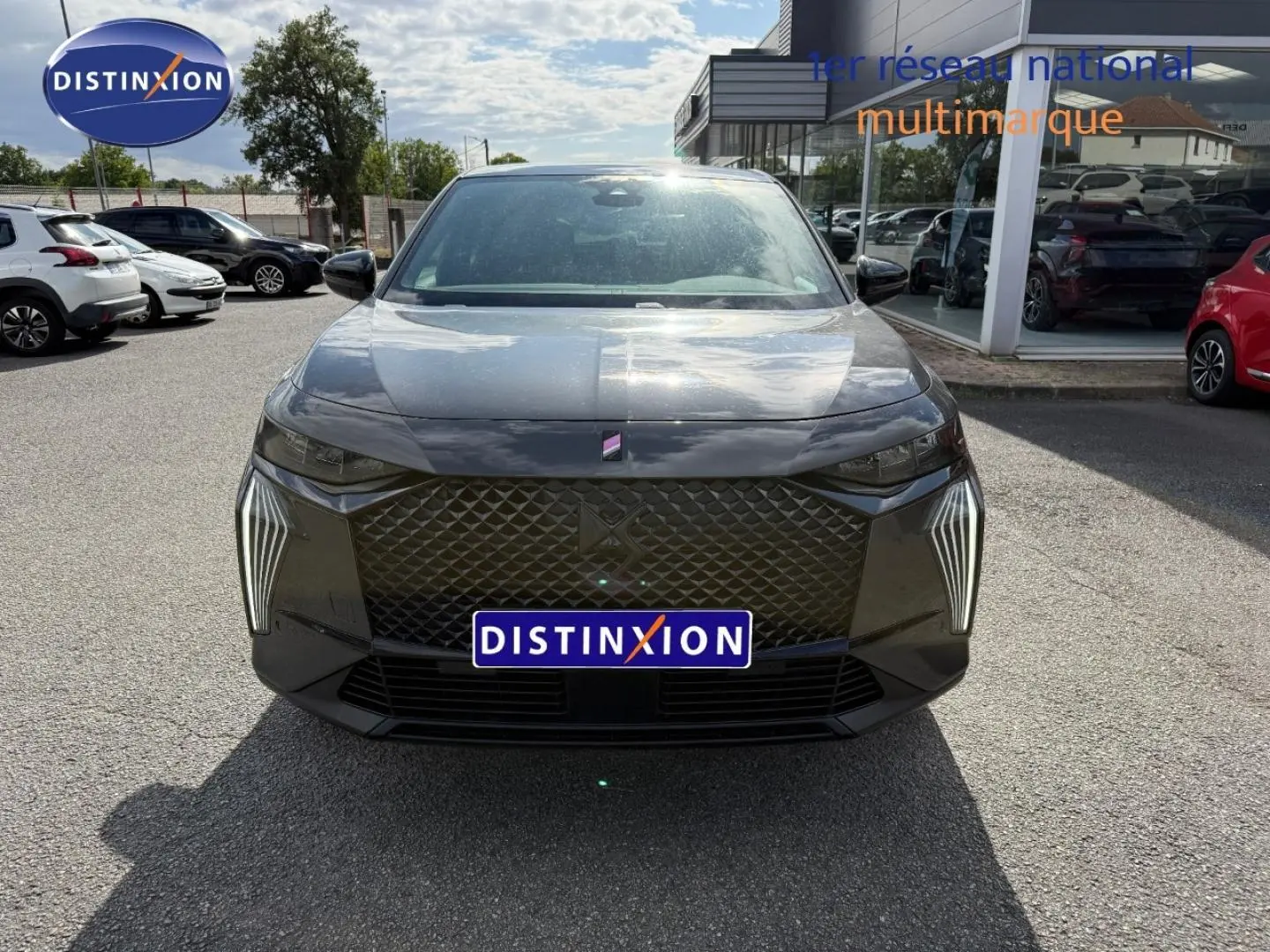 Vue frontale d'un DS7 E-TENSE 225ch Performance Line + gris titane avec calandre distinctive et feux LED verticaux.