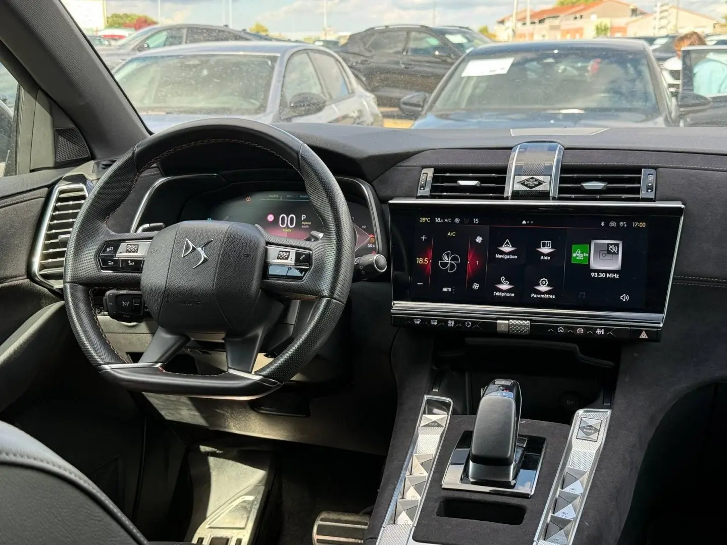 Vue intérieure centrée sur le volant et l’écran tactile du tableau de bord du DS7 E-TENSE gris Titane.