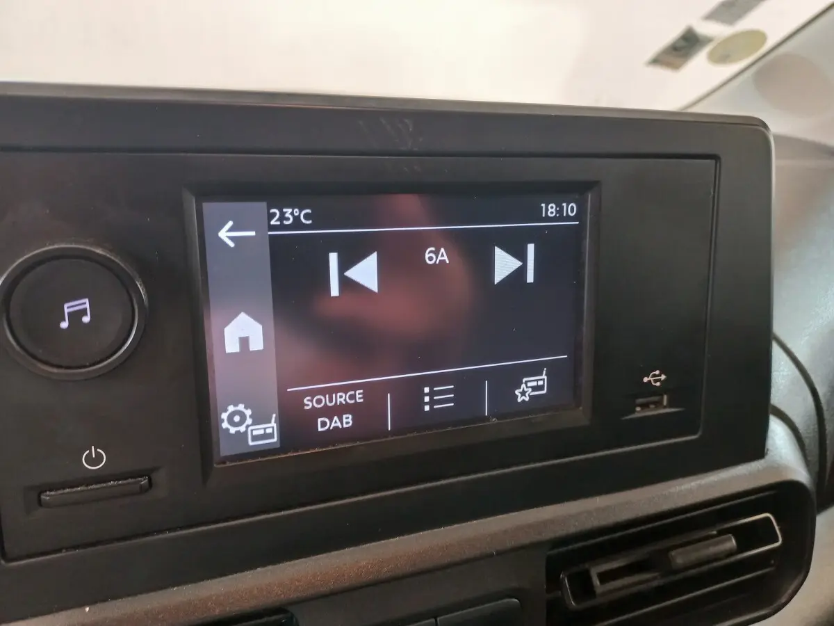 Écran tactile central du tableau de bord du Peugeot Partner 2021 affichant la source radio DAB, avec port USB à droite.