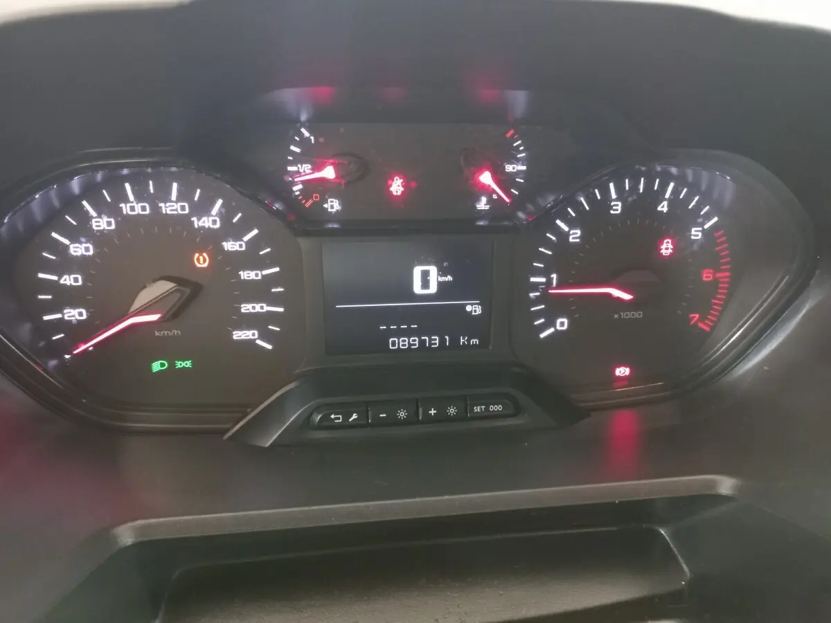 Tableau de bord du Peugeot Partner 2021 avec compteur digital et voyants allumés, vue frontale rapprochée.