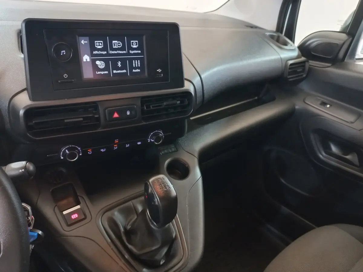 Vue intérieure côté passager du tableau de bord noir du Peugeot Partner 2021 avec écran tactile et levier de vitesses manuel.