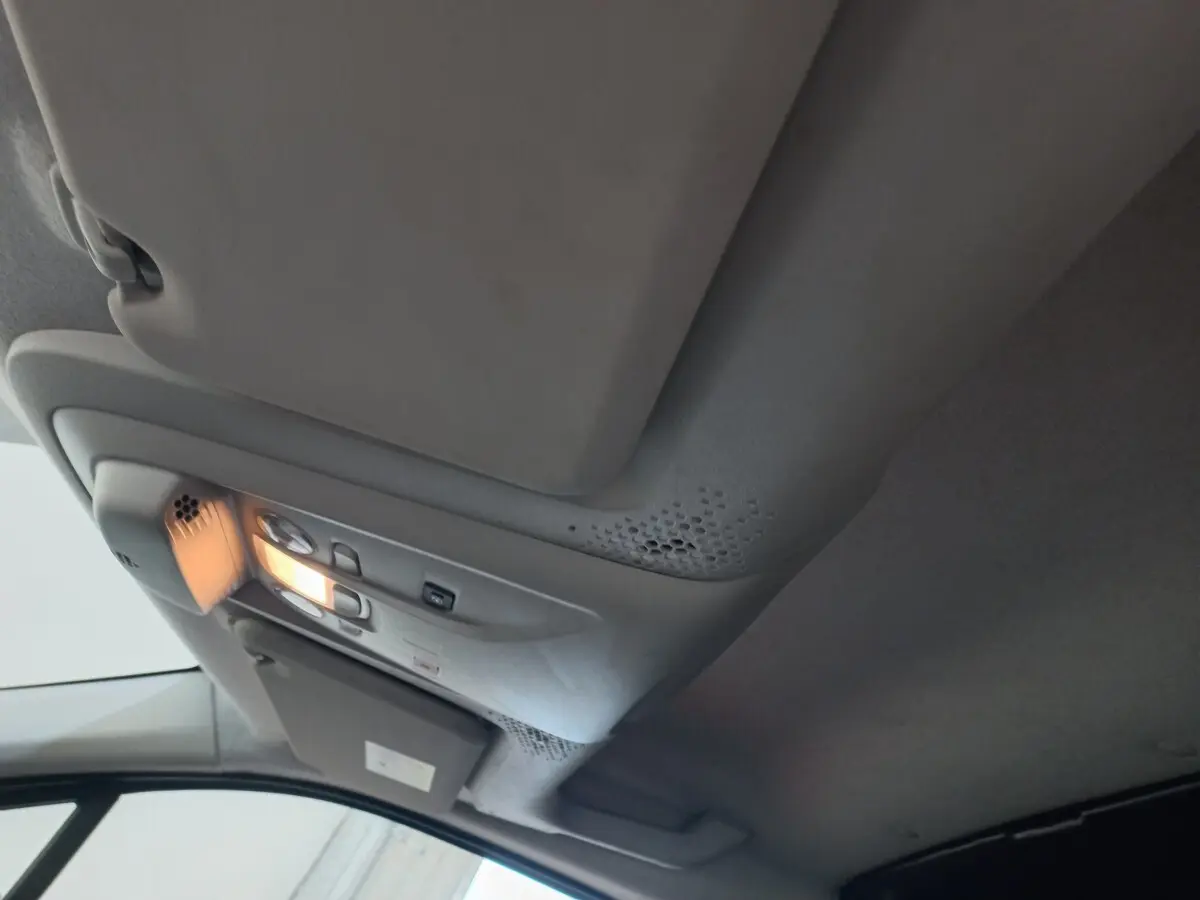 Vue intérieure du plafond avant du Peugeot Partner blanc 2021 avec éclairage de cabine allumé et pare-soleil côté conducteur.