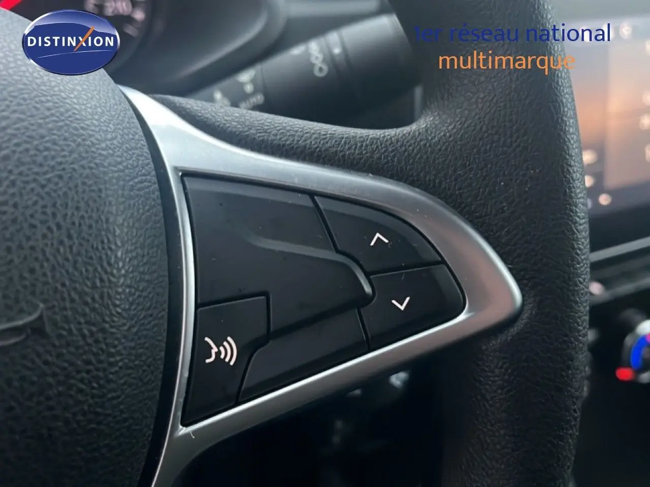 Gros plan sur les commandes du volant noir du Renault Express Van blanc glacier, version TCE 100CH Confort 2023.