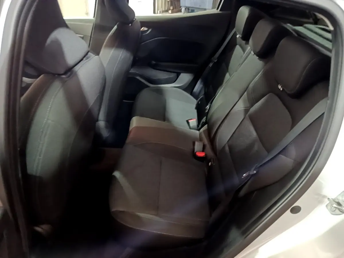 Vue intérieure côté droit montrant la banquette arrière noire d'une Renault Clio 2023 gris clair avec ceinture de sécurité.