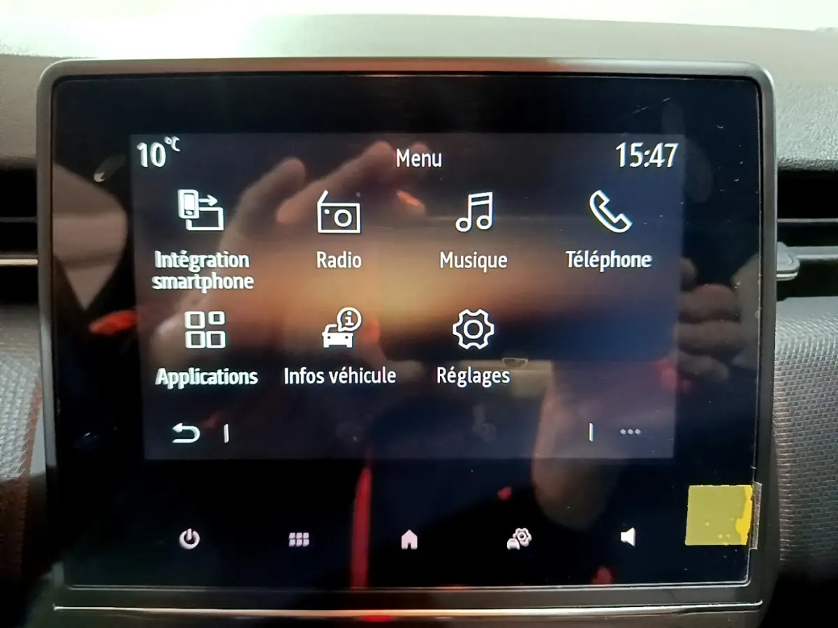 Écran tactile central de la Renault Clio 2023 affichant le menu principal avec options smartphone, radio et réglages.