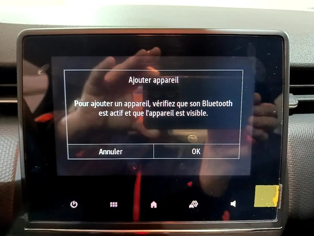 Écran tactile central de la Renault Clio gris clair 2023 affichant un message d'ajout d'appareil Bluetooth.