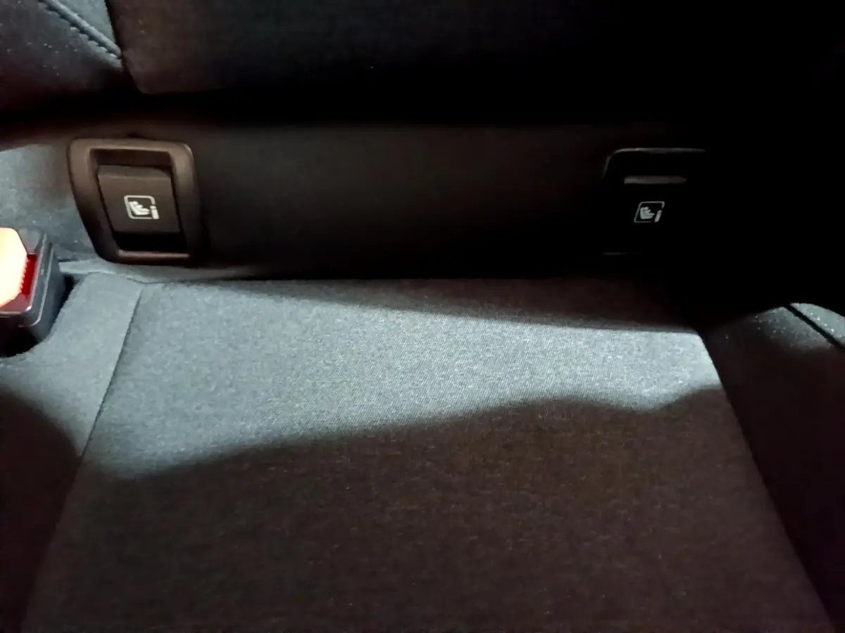 Détail du plancher arrière avec commandes de rabattement des sièges sur Renault Clio gris clair 2023.