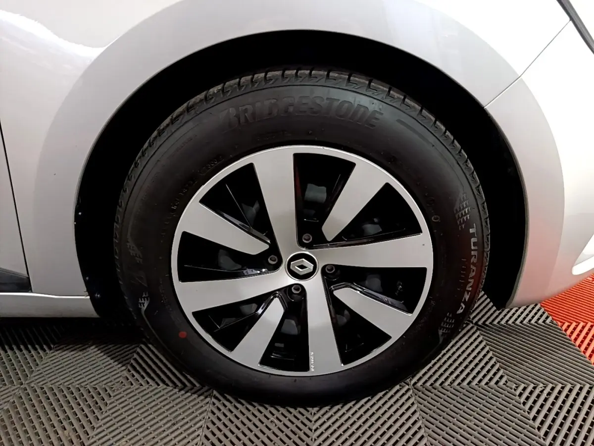 Gros plan sur la roue avant droite gris clair de la Renault Clio 2023 avec jante noire et argentée au design moderne.