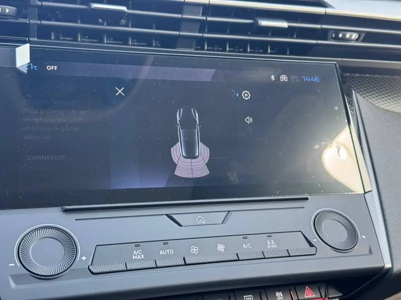 Écran tactile central de la Peugeot 308 2025 blanc Okénite montrant l’aide au stationnement arrière.