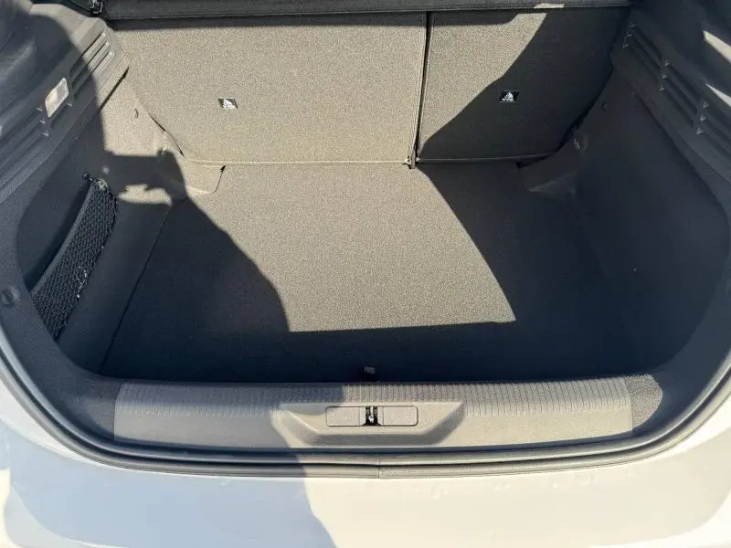 Coffre ouvert vu de dessus d'une Peugeot 308 blanche, montrant un espace de rangement propre et spacieux.
