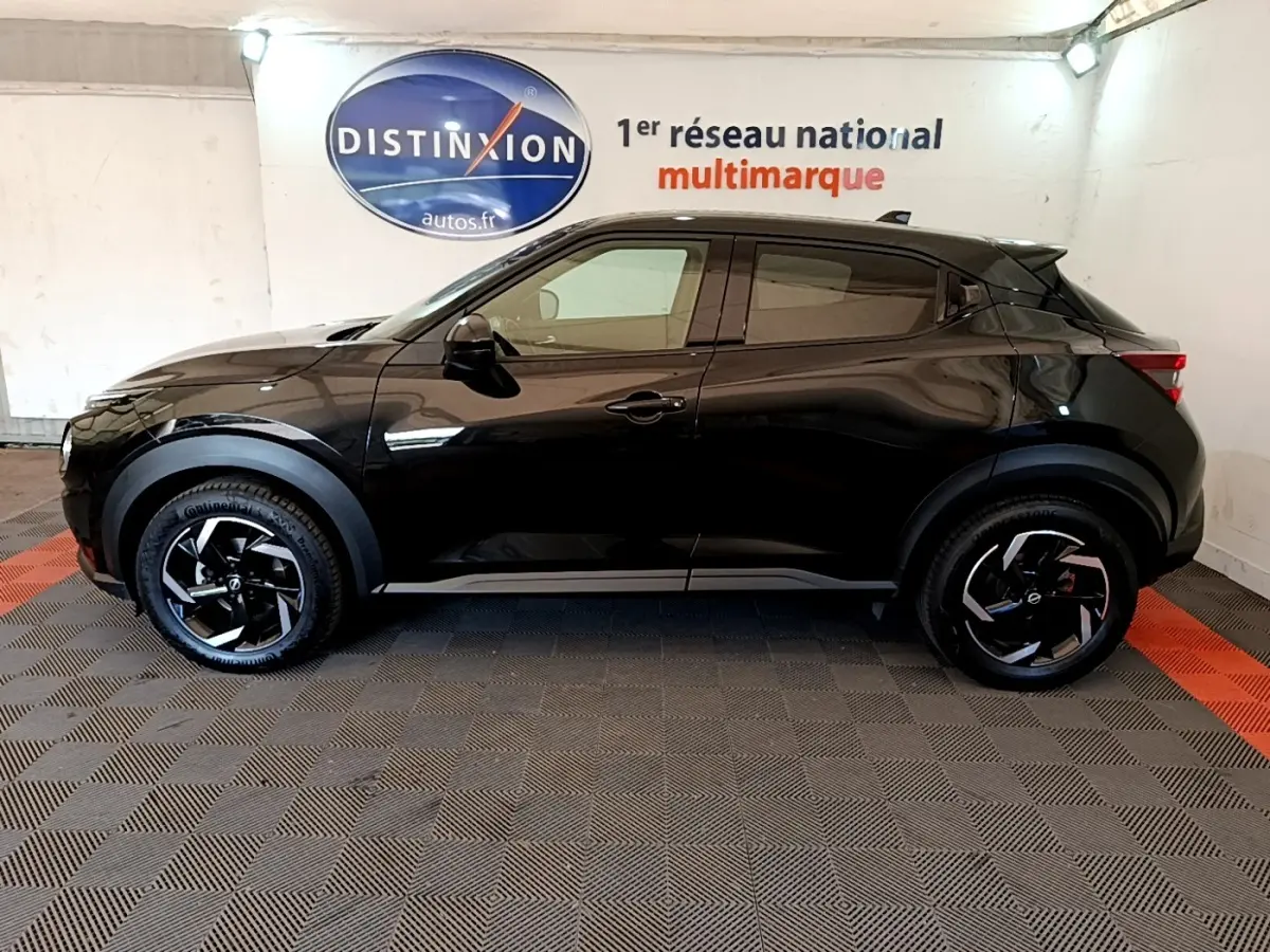 Vue de profil côté gauche d'un Nissan Juke DIG-T 114 DCT noir avec jantes noires et détails de carrosserie marqués.