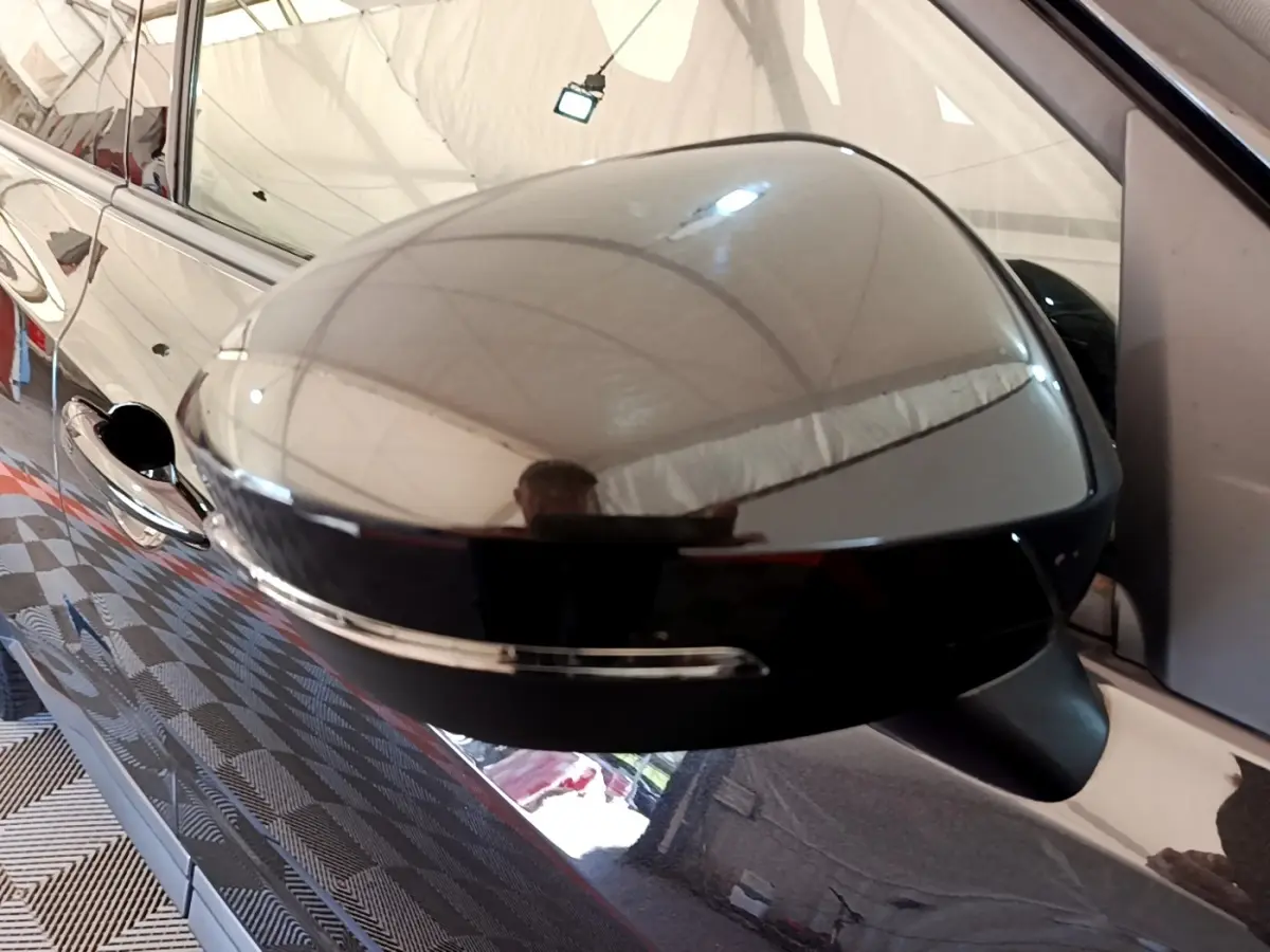 Rétroviseur extérieur noir brillant côté gauche d’un Nissan Juke 2022 avec clignotant intégré, vue rapprochée.