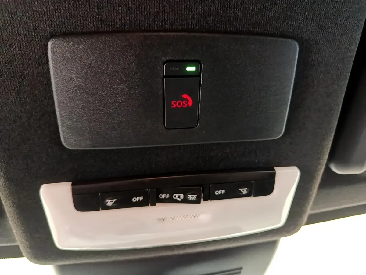 Vue intérieure du toit d’un Nissan Juke noir 2022, avec bouton d’appel d’urgence SOS et commandes d’éclairage.