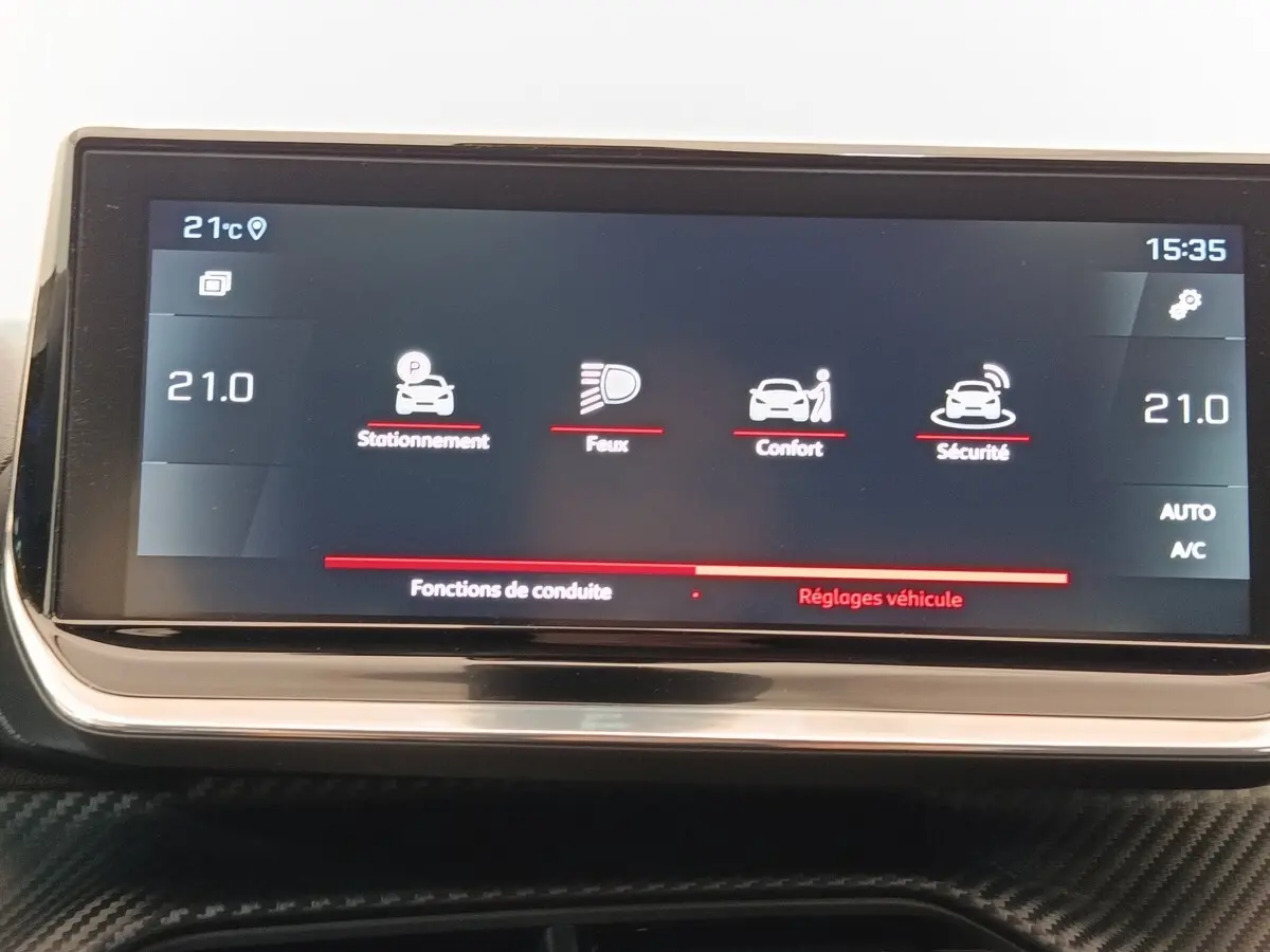 Écran tactile central de 10 pouces affichant les réglages de stationnement, feux, confort et sécurité dans une Peugeot 208 blanche.