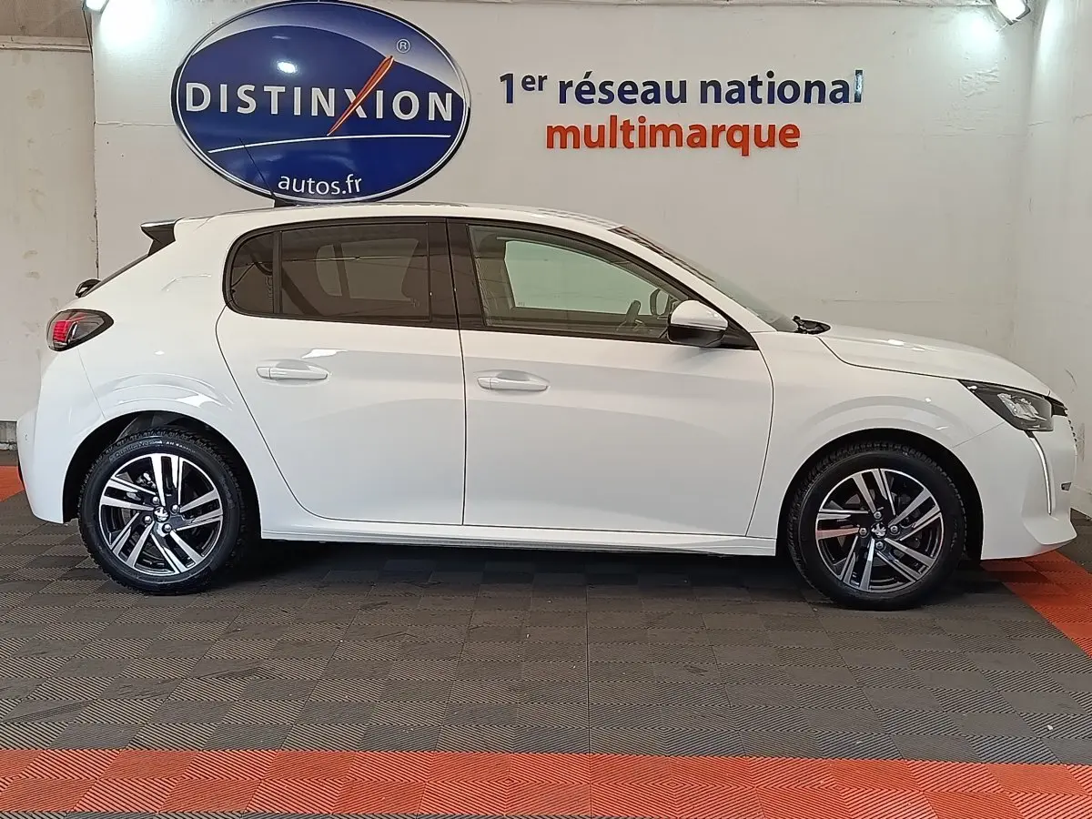 Profil droit d'une Peugeot 208 blanche PureTech 100 S&S Allure Business de 2021, roues alliage et rétroviseurs blancs.