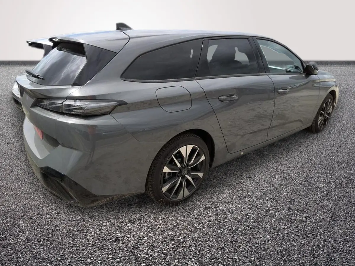 Peugeot 308 Hybrid gris foncé vue 3/4 arrière droit, avec vitres teintées et jantes alliage noires.