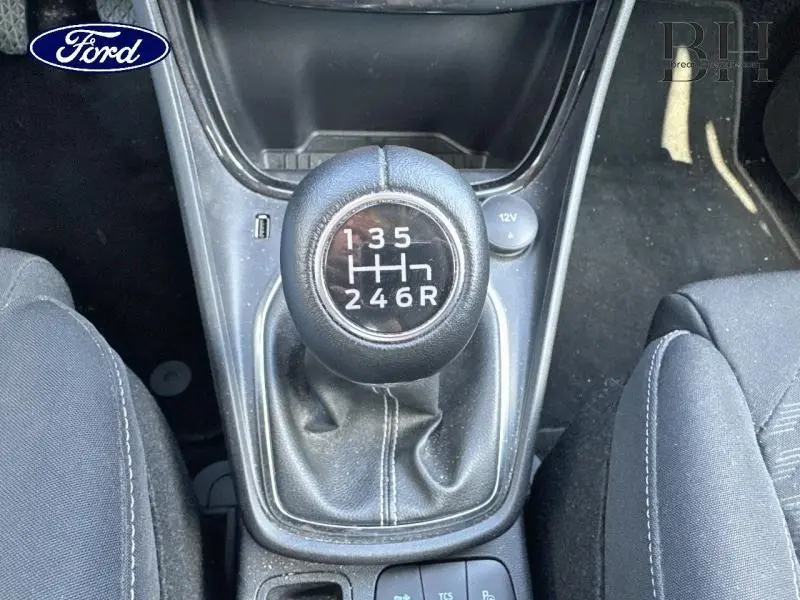Vue rapprochée du levier de vitesses manuel noir du Ford Puma blanc Glacier, entouré des sièges en tissu noir Kasbah.