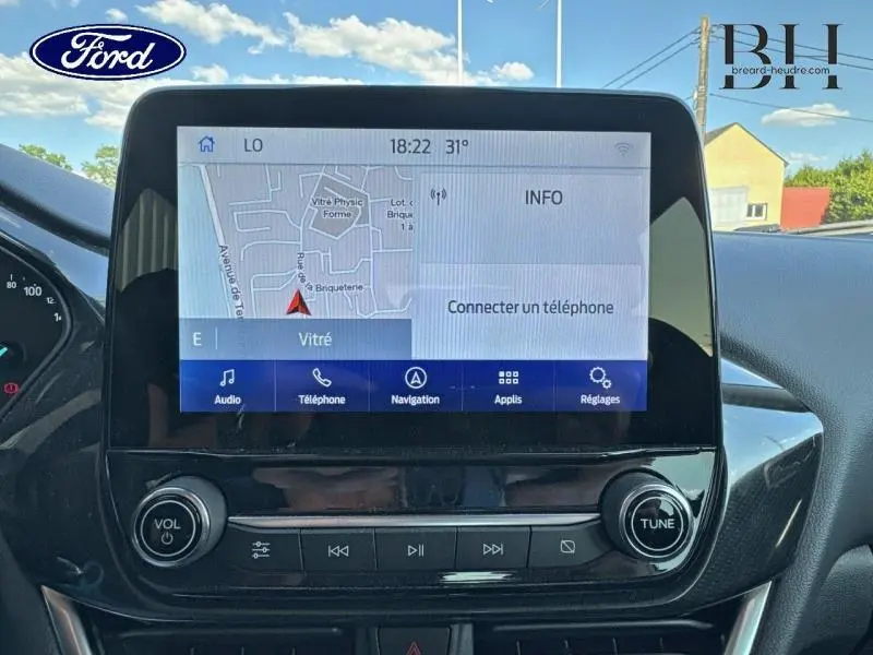 Écran tactile central de la Ford Puma 2024 blanc glacier, affichant la navigation et les options multimédia.