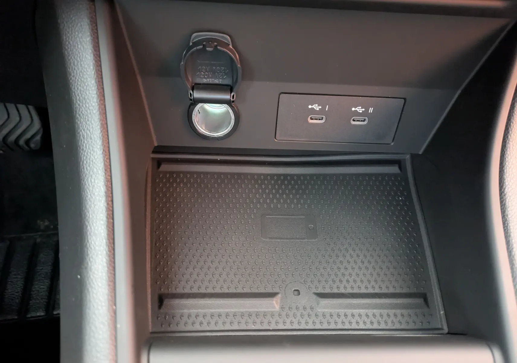 Gros plan sur la console centrale du Renault Captur E-Tech 2025 montrant prise 12V et ports USB-C noirs.