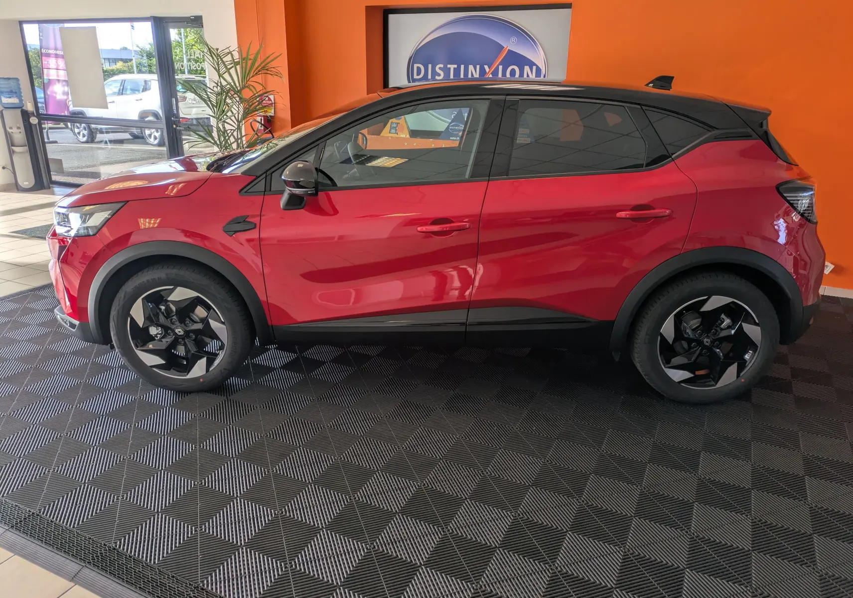 Profil côté gauche du Renault Captur E-Tech Full Hybrid 160 Techno rouge flamme avec toit noir et jantes alliage 18 pouces.