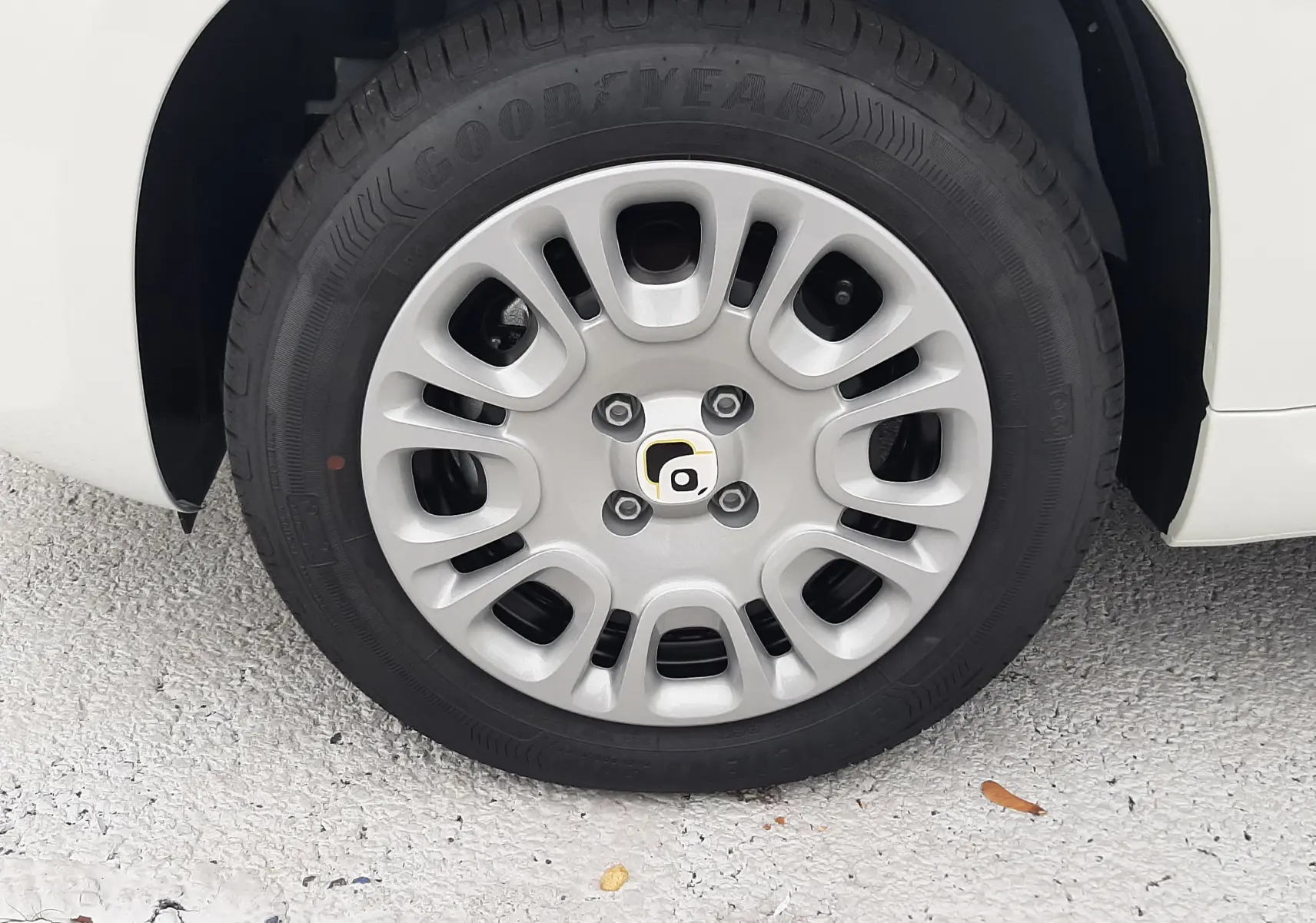 Gros plan sur la roue avant gauche d'une Fiat Panda blanc gelato avec jante en alliage et pneu Goodyear.
