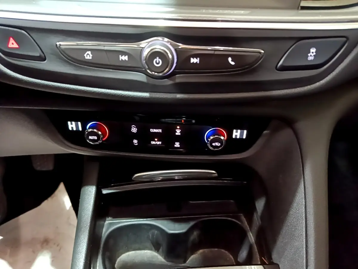Gros plan sur la console centrale noire de l’Opel Insignia 2019, avec commandes climatisation digitale et boutons multifonctions.