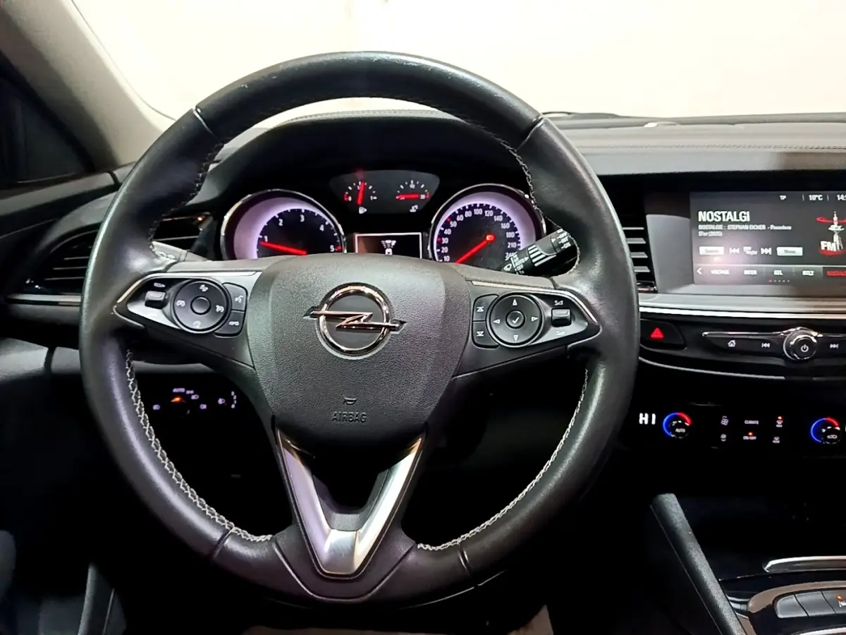 Vue intérieure centrée sur le volant cuir noir de l'Opel Insignia 2019 avec tableau de bord et écran tactile visible.