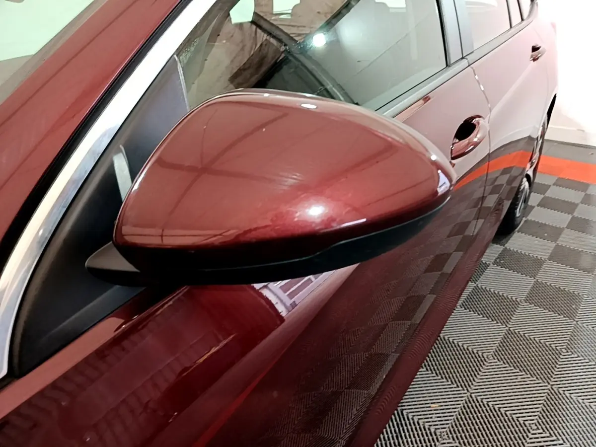 Rétroviseur côté gauche d’une Opel Insignia rouge 2019, vue rapprochée sur la portière et la poignée.
