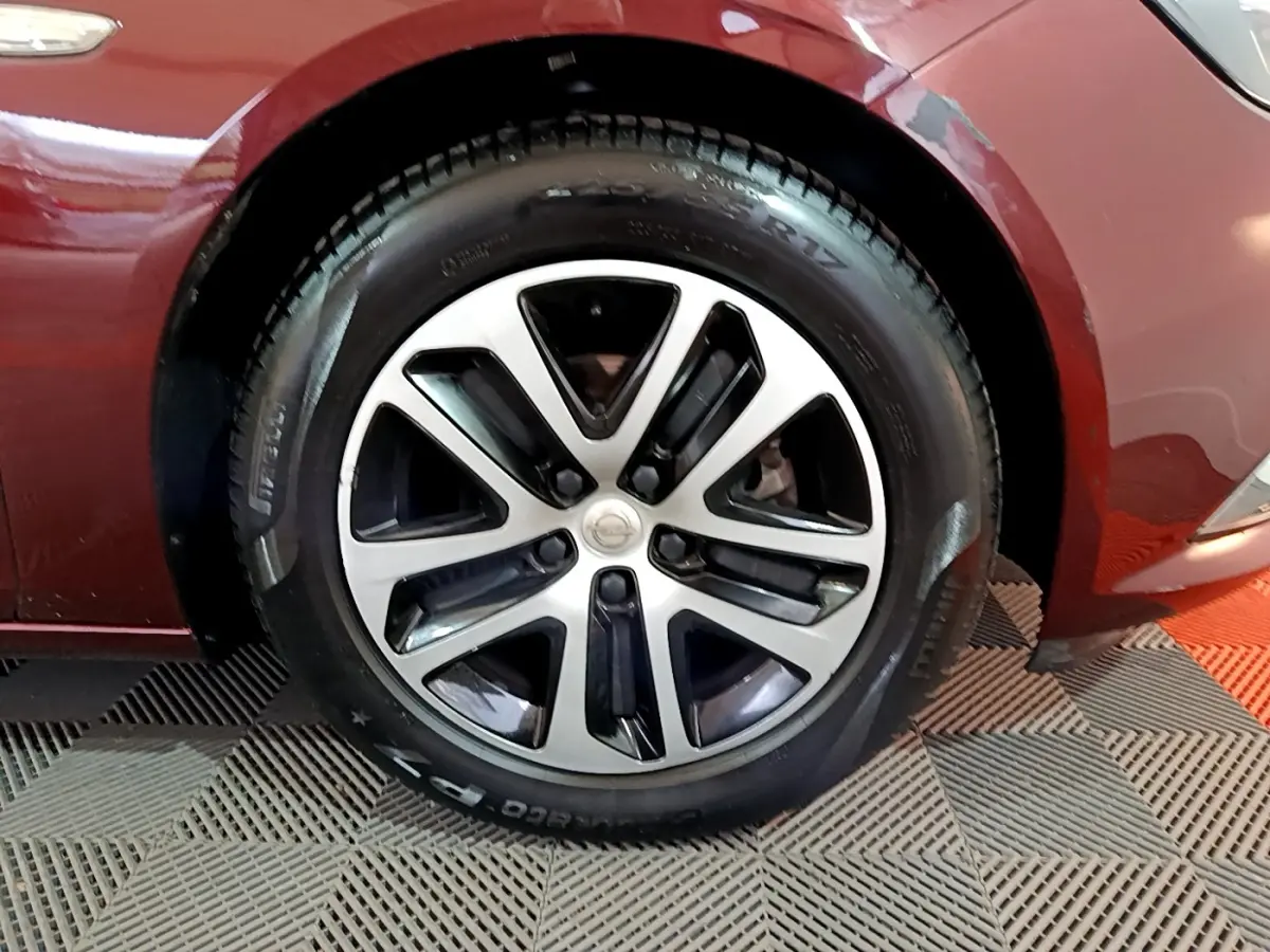 Gros plan sur la roue avant droite d’une Opel Insignia rouge 2019 avec jante alliage bicolore.