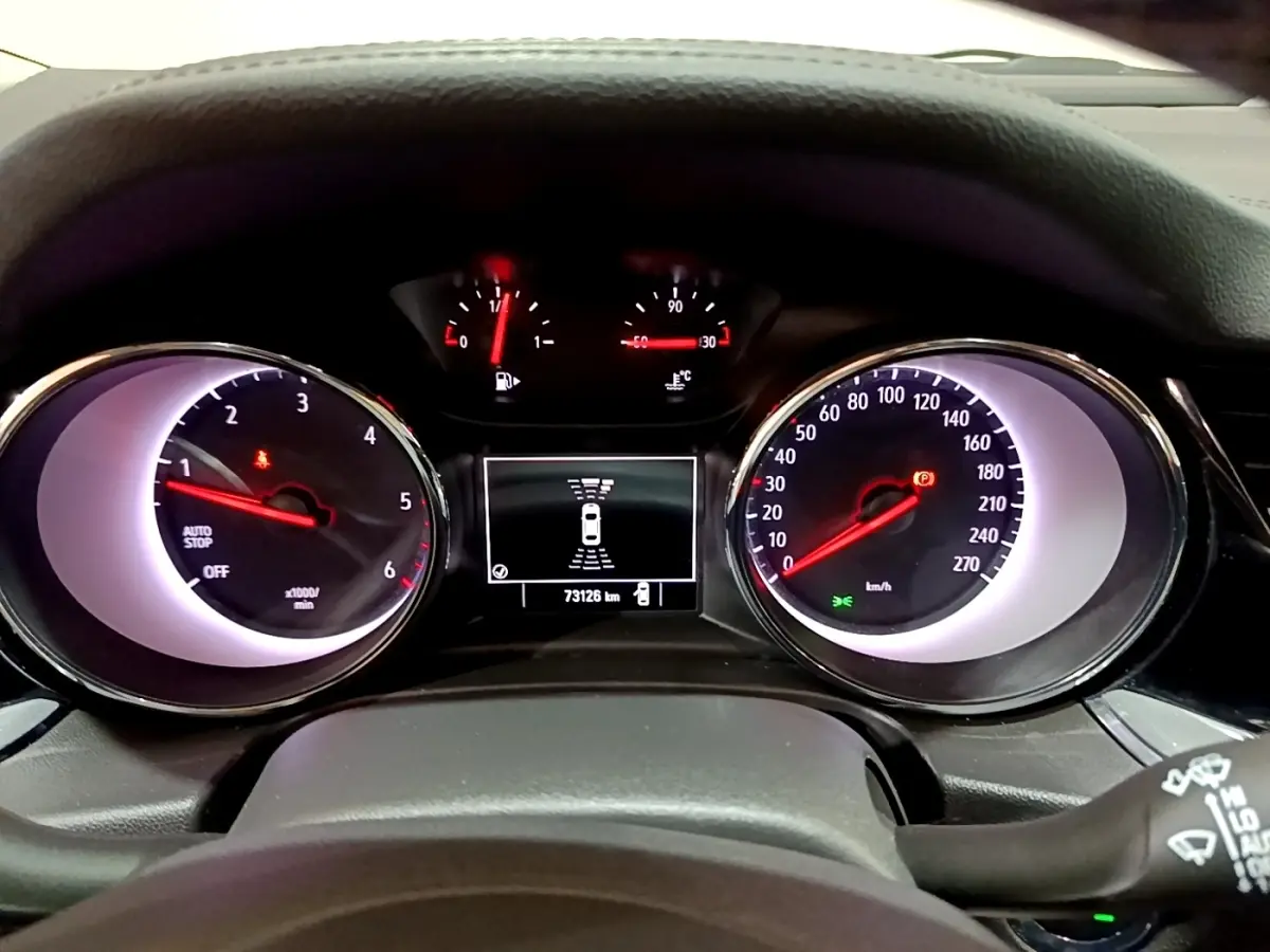 Vue rapprochée du tableau de bord de l’Opel Insignia 2019, affichage digital et compteurs analogiques éclairés.