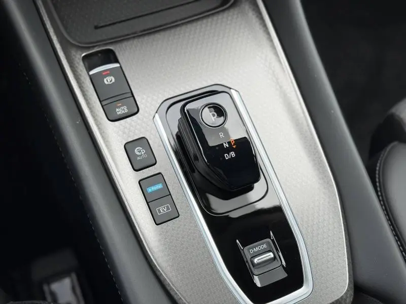 Gros plan sur la console centrale grise du Nissan Qashqai Hybrid e-POWER 2025 avec sélecteur de vitesses électronique et boutons de contrôle.