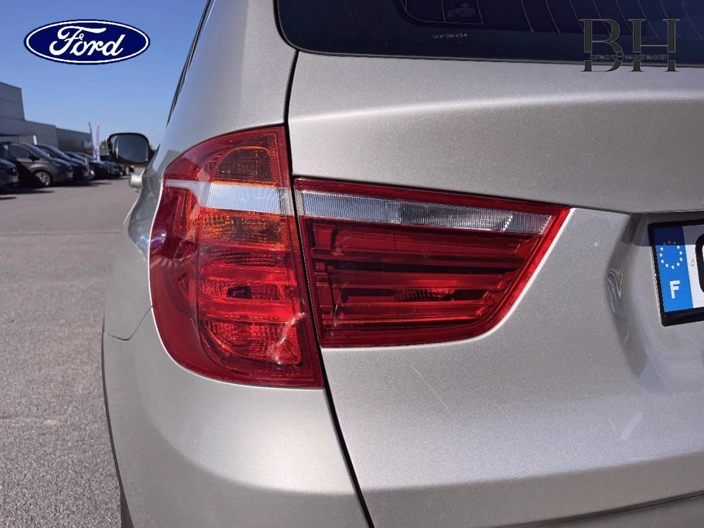 Feu arrière gauche en gros plan sur BMW X3 Mineralsilber vue 3/4 arrière, avec carrosserie argentée brillante.