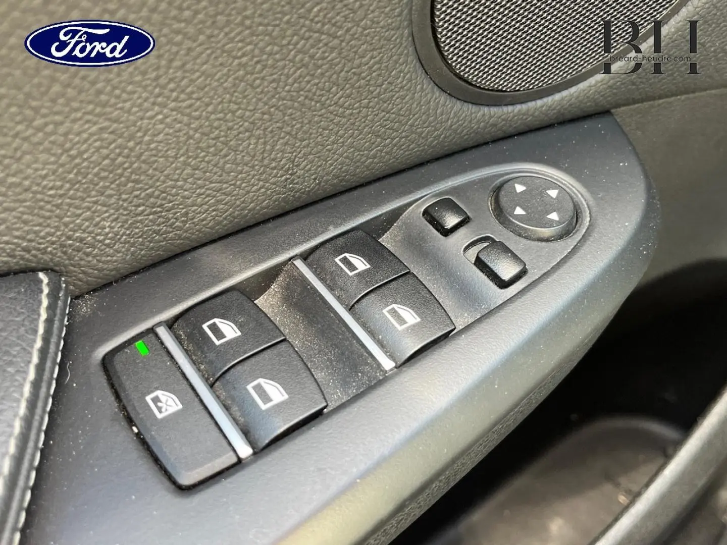Commande des vitres électriques côté conducteur en plastique noir dans une BMW X3 Mineralsilber, vue intérieure rapprochée.