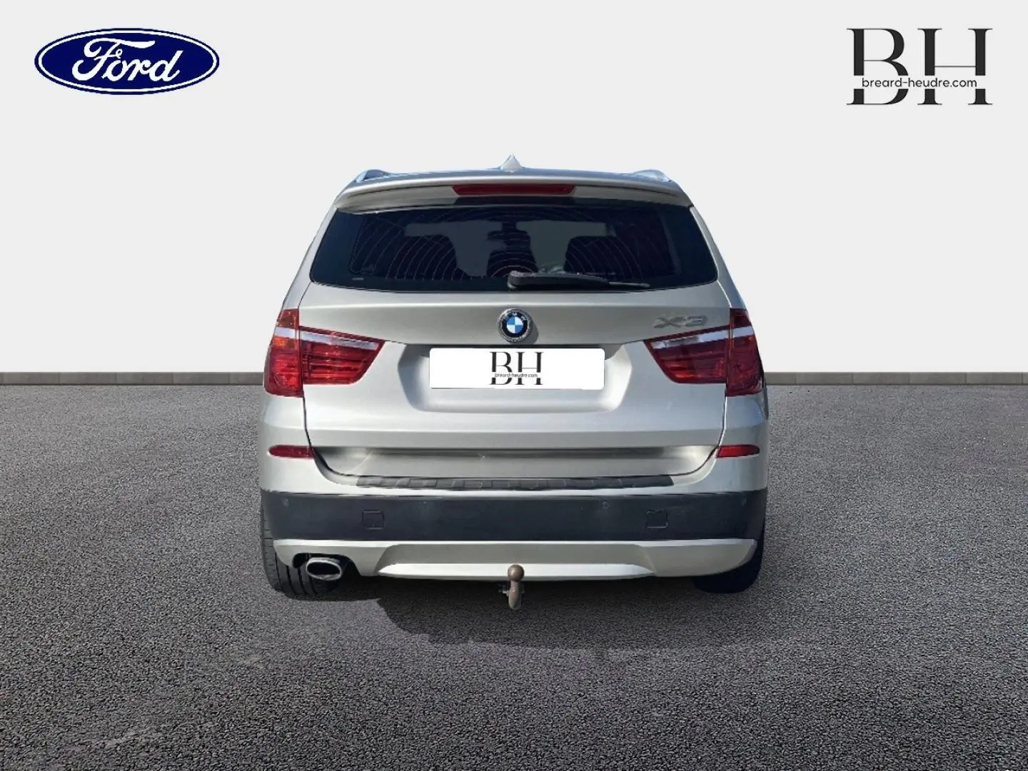 Vue arrière d'un BMW X3 Mineralsilber 2013 avec attelage et feux arrière rouges visibles.