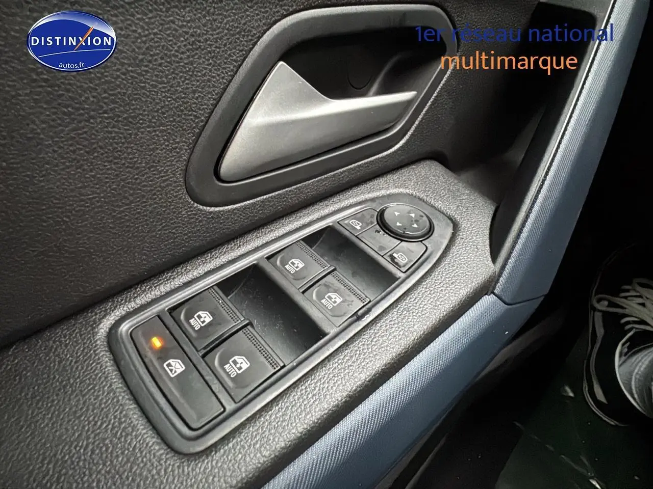 Gros plan sur les commandes des vitres électriques côté conducteur du Dacia Duster 2025 avec bouton de verrouillage activé.