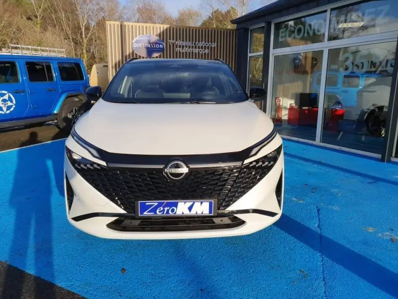 Vue avant d'un Nissan Qashqai Hybrid e-POWER 2025 blanc nacré avec toit noir, calandre noire distinctive.