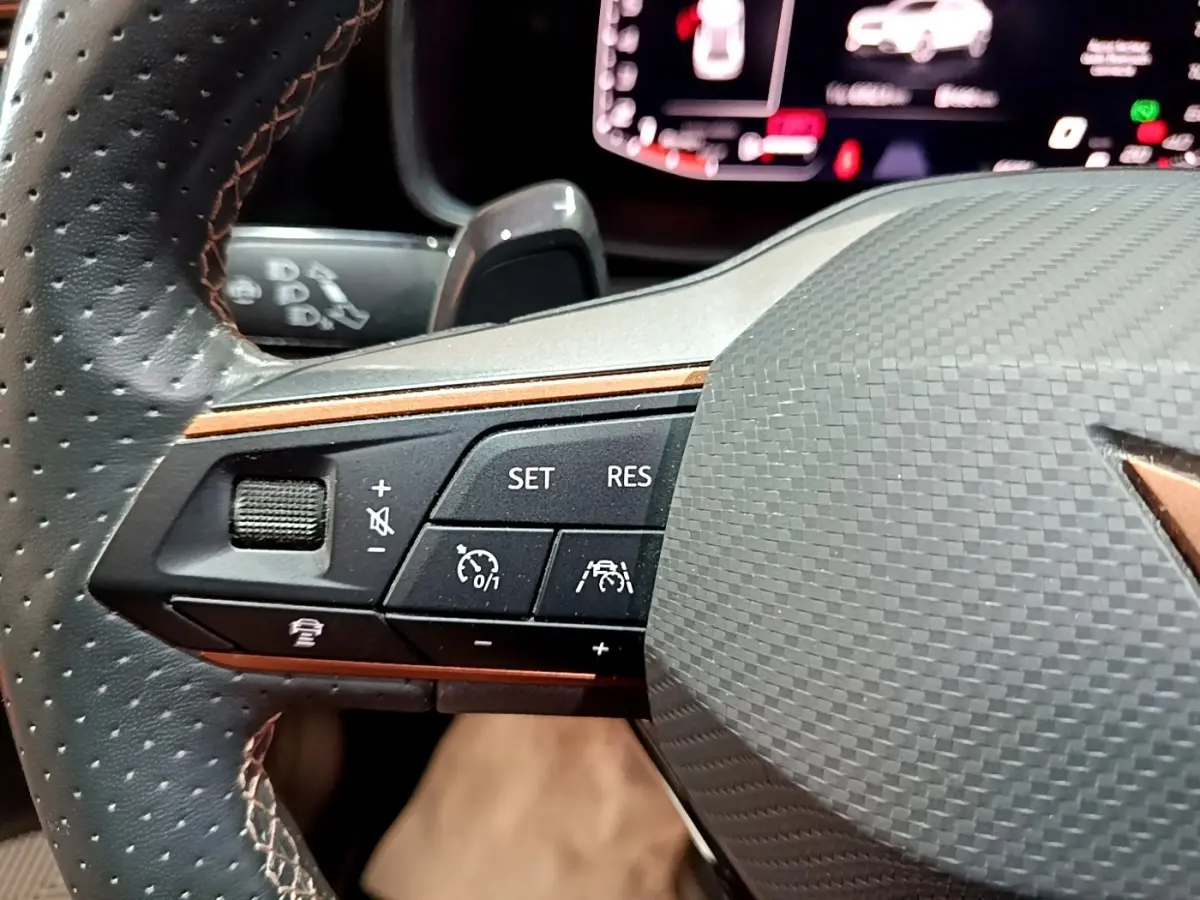 Gros plan sur le volant cuir et alu de la CUPRA Formentor gris foncé, avec commandes multifonctions et affichage digital.