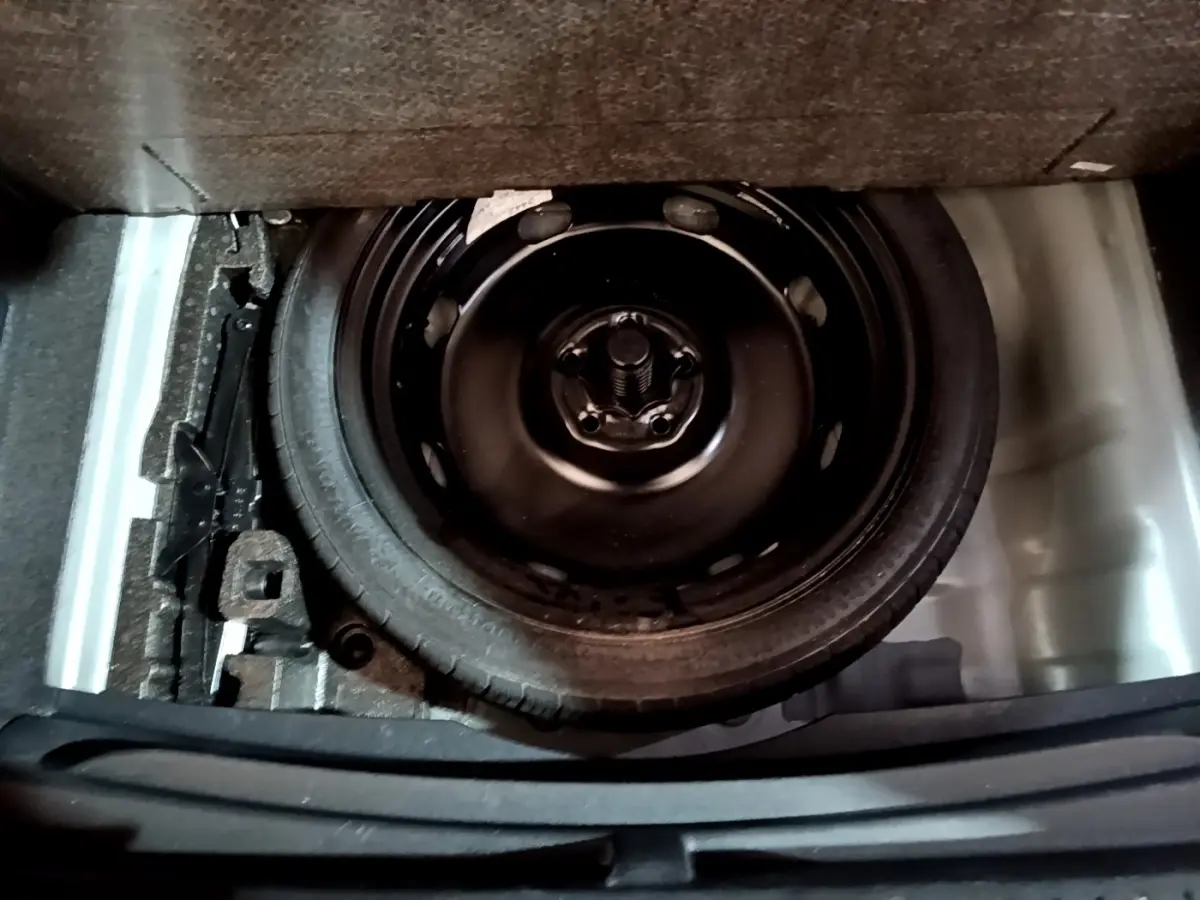 Vue plongeante sur la roue de secours noire dans le coffre du CUPRA Formentor gris foncé 2024.