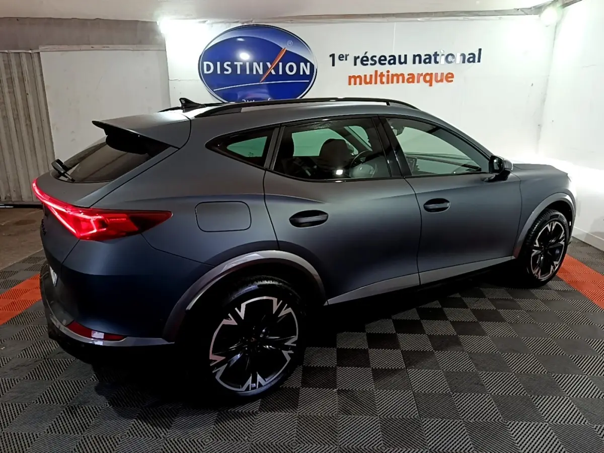 Vue 3/4 arrière droite d'un CUPRA Formentor gris foncé 2024 avec feux LED et jantes noires distinctives.