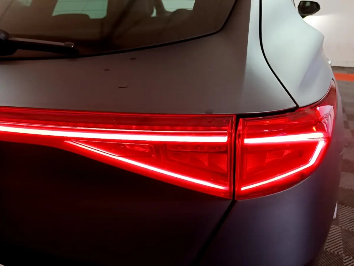 Gros plan sur le feu arrière droit rouge allumé du CUPRA Formentor gris foncé, soulignant la ligne lumineuse fine.