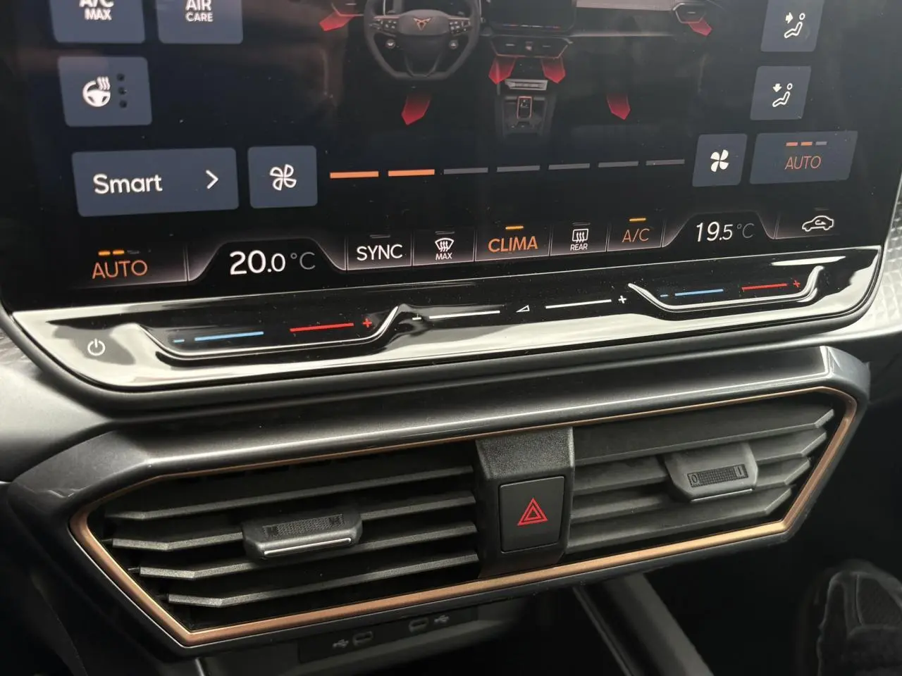 Gros plan sur la console centrale du Cupra Formentor blanc, montrant l'écran tactile et les commandes de climatisation.