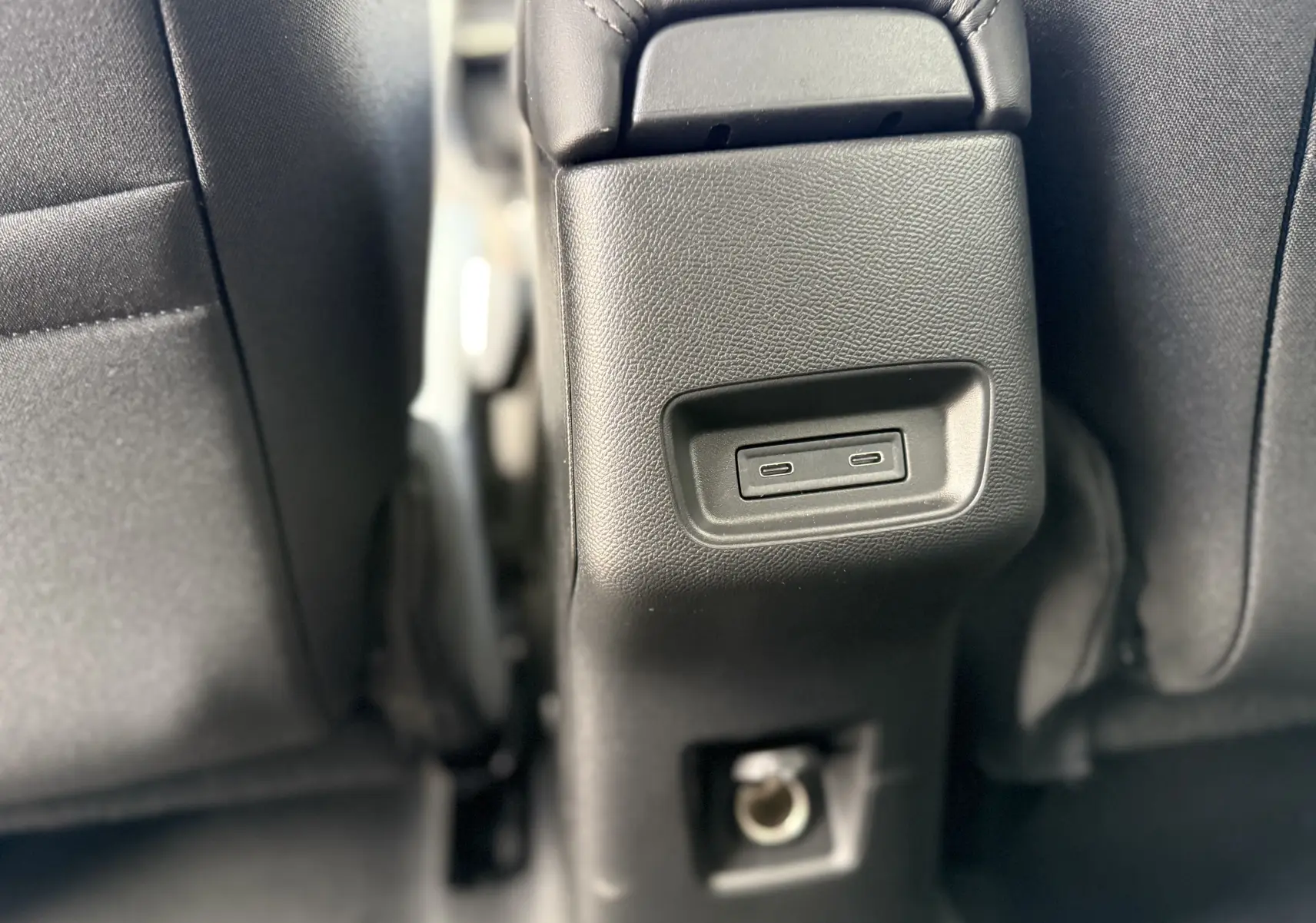 Gros plan sur la console arrière entre les sièges noirs du Citroën C3 Aircross Hybrid 145, montrant deux ports USB-C.