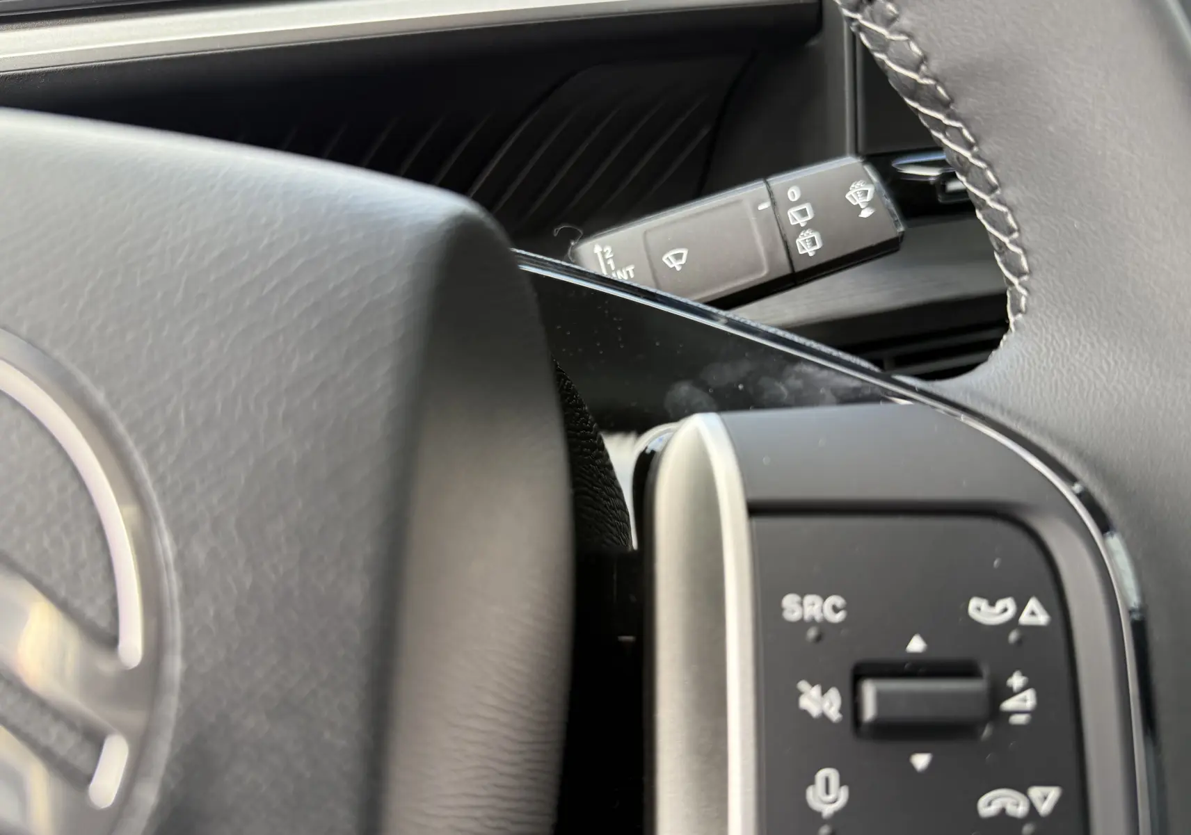 Détail du volant et des commandes au volant d'une Citroën C3 Aircross Hybrid 145, finition 2026, avec cuir et boutons multifonctions.