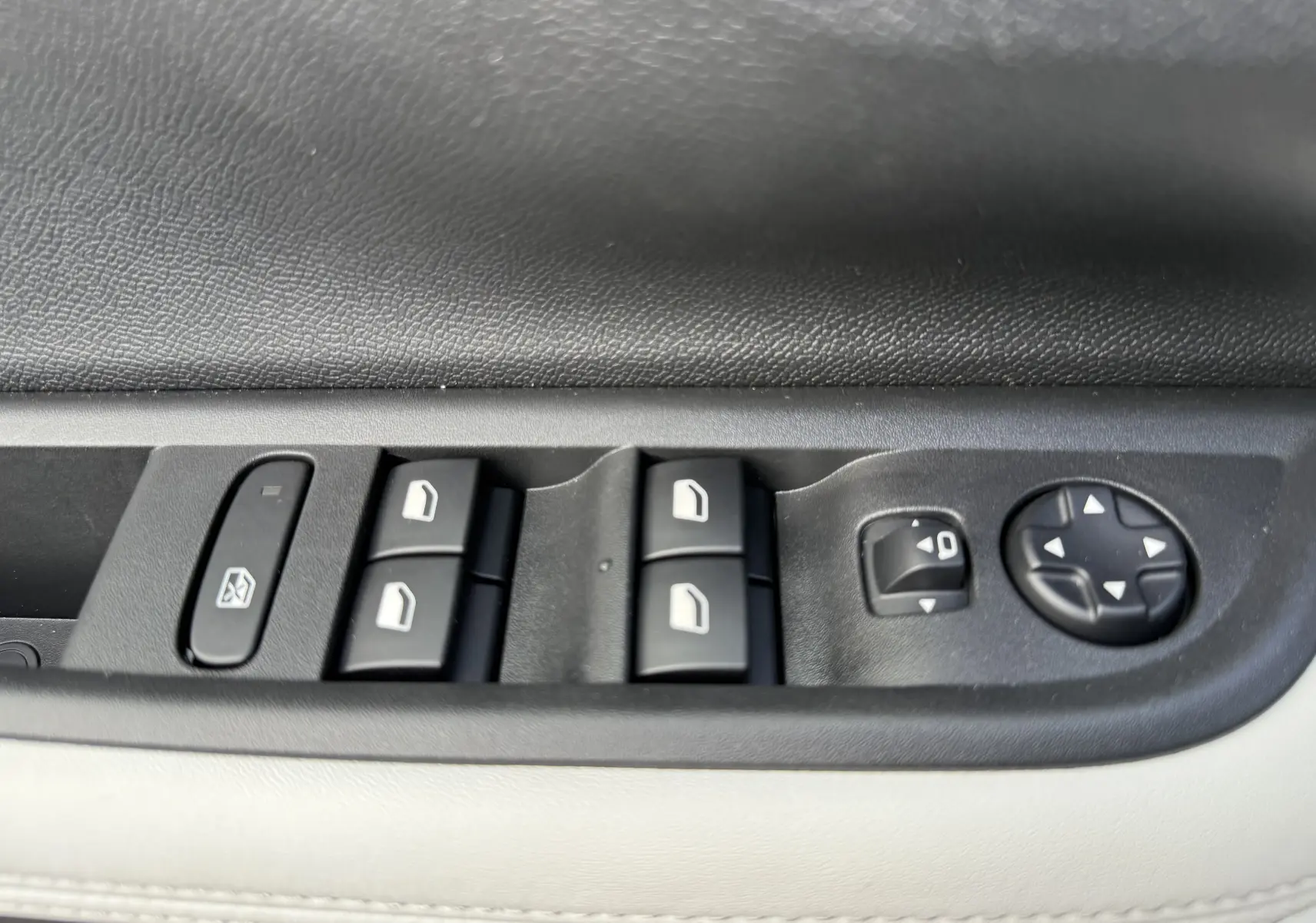 Gros plan sur les commandes de lève-vitres et réglage des rétroviseurs côté conducteur du Citroën C3 Aircross blanc banquise toit noir.