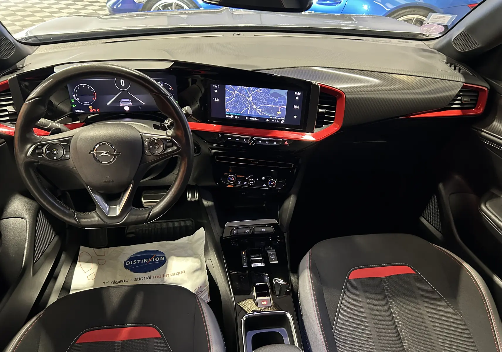 Intérieur de l’Opel Mokka GS Line 2022, vue tableau de bord avec écran central, volant cuir et inserts rouges.
