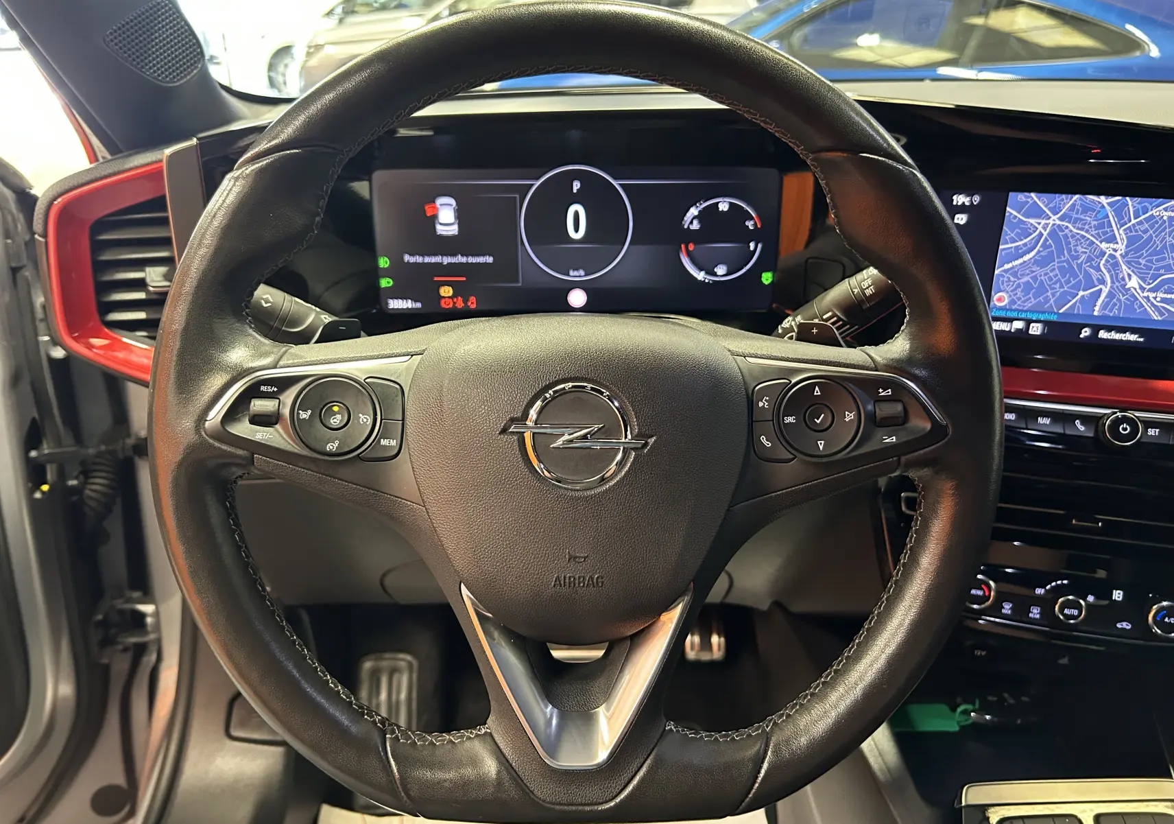Vue centrée sur le volant noir de l'Opel Mokka GS Line 2022 avec tableau de bord numérique et écran GPS en arrière-plan.